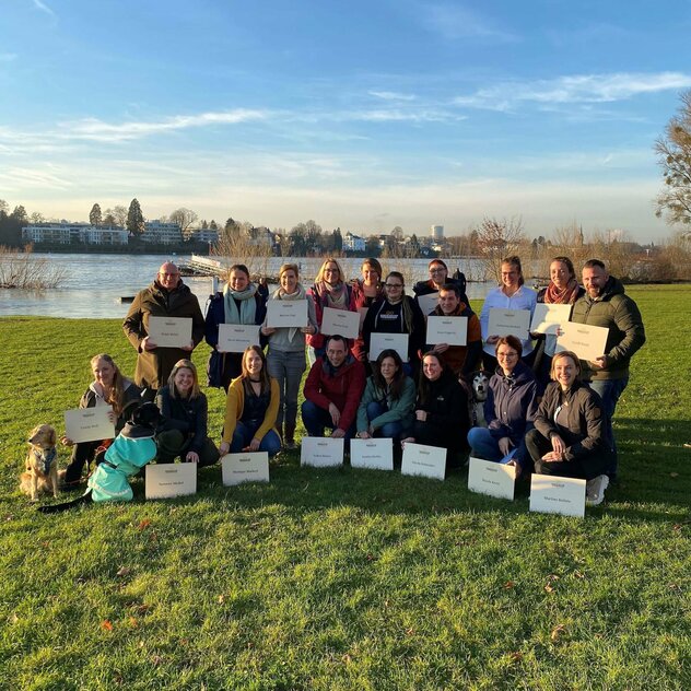 Ein Gruppenbild, wo die Menschen ihre Markenlizenzen hochhalten