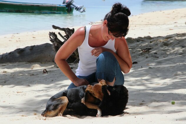 Raufende Welpen mit Doreen Hörchner am Strand auf La Digue, Seychellen