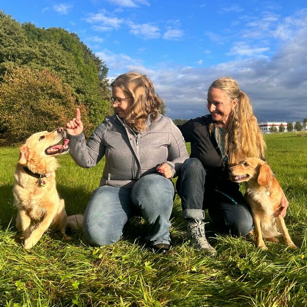 Conny und Susann auf der Wiese mit zwei Hunden der Hundeschule für Dresden und Bautzen