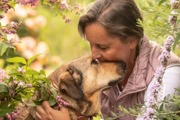 Frau mit Hund in den Blumen