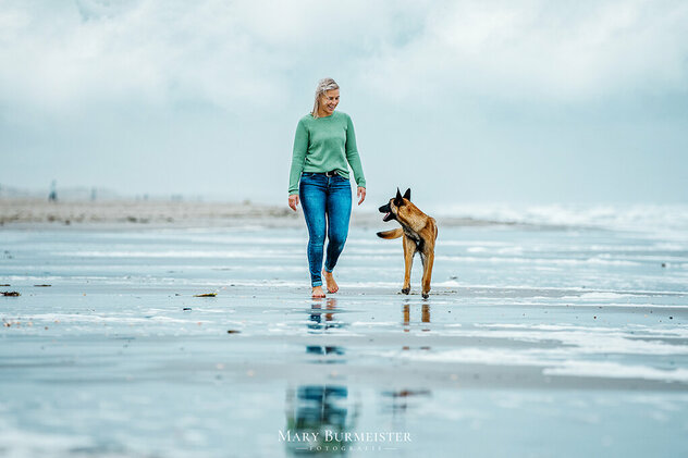 Frau mit Hund am Strand