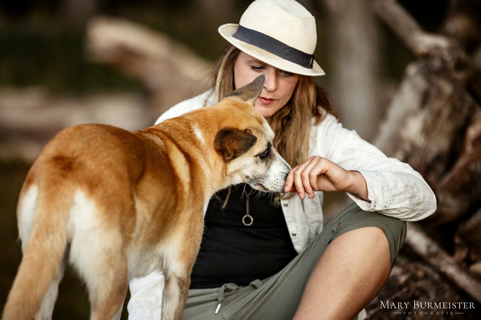 Frau mit Hut und Hund im Wald
