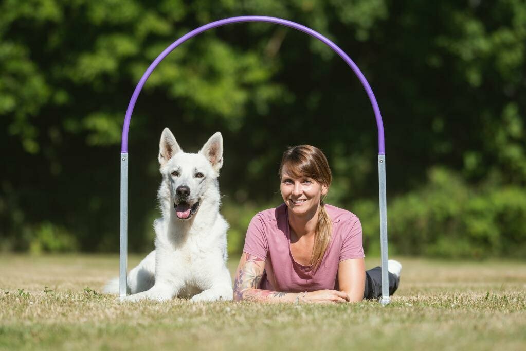 Hund und Mensch liegen im Hoop