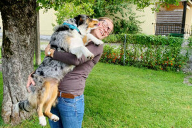 Anna-Lena mit Cleo im Arm auf grüner Wiese