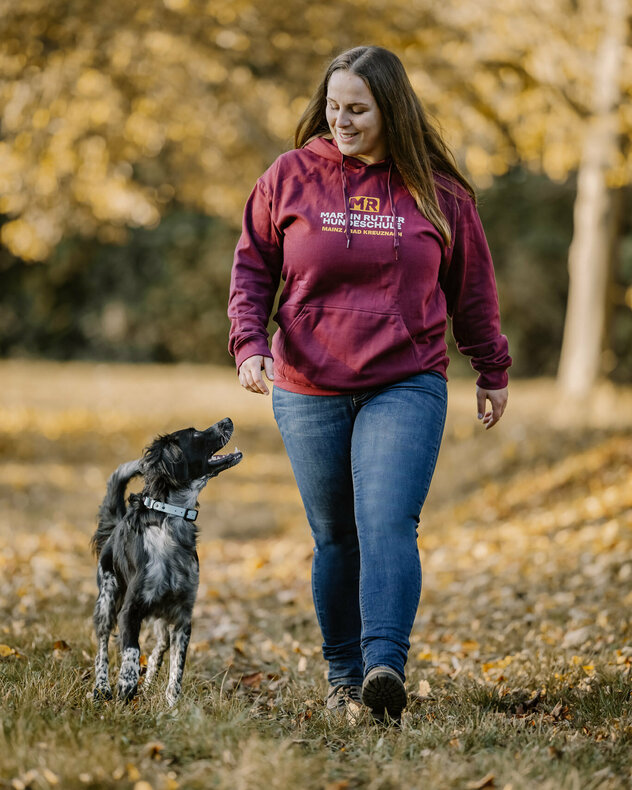 Hundetrainerin Patricia läuft mit ihrem Hund Winnie nebeneinander